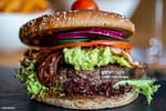 A huge burger with guacamole.