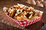 An image of a Canadian Poutine. An open faced sandwich with fries, gravy and everything but the kitchen sink!