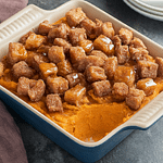 Cider donut croutons on top of a sweet potato casserole.